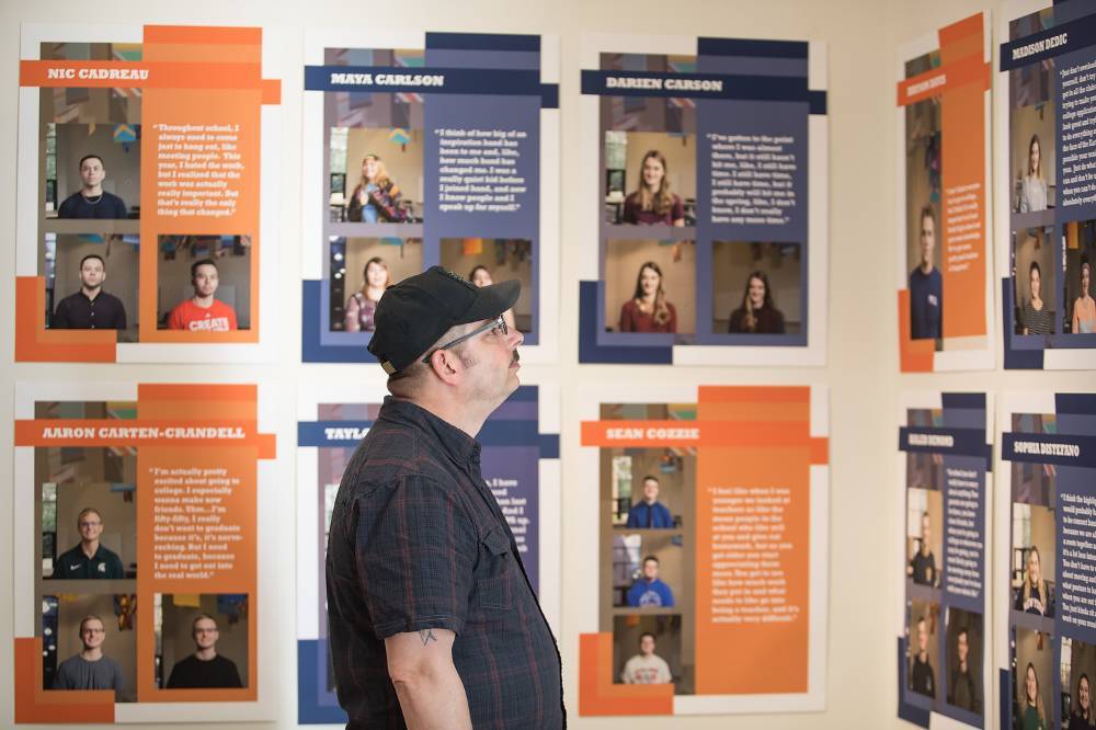A man framed against a wall of stories from Contemporary Stories of Saugatuck